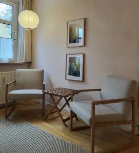 Terapilokale i Nygade. To stole og et lille bord foran et vindue med kig til himmel og et træ. Her kan en psykolog, psykoterapeut eller terapeut sidde og hjælpe en klient med samtaleterapi.